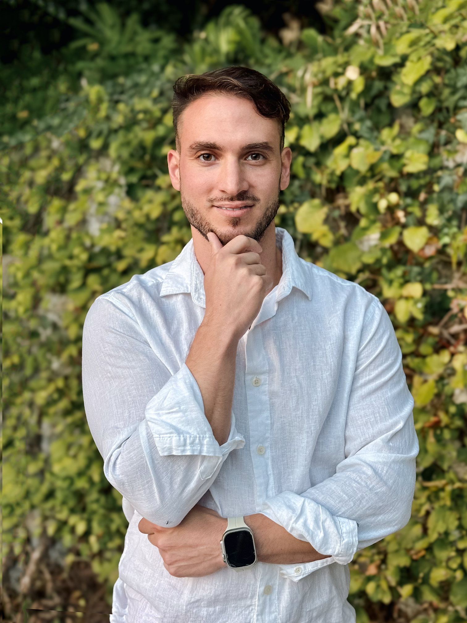 Smiling person outdoors surrounded by lush green trees, bathed in warm sunlight with soft natural lighting and a gentle breeze, creating a peaceful and joyful nature scene.